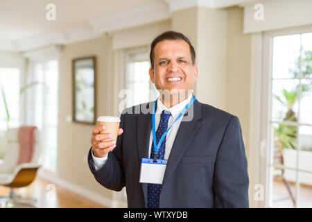 Mittleres Alter Geschäftsmann, trinken eine Tasse Kaffee tragen ID-Karte Stockfoto