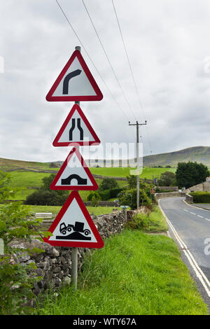 Mehrere Warnzeichen auf der Straße nähert sich eine scharfe Kurve und Buckelwale Brücke auf der B 6479 im Dorf von Horton-in-Ribblesdale, North Yorkshire. Stockfoto