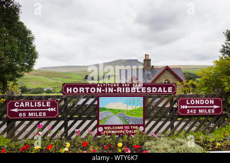 Meilen Entfernung Anzeichen für Carlisle und London auf dem Bahnhof in Horton-in-Ribblesdale, North Yorkshire Übersehen von entfernten Pen-Y-Gent Stockfoto