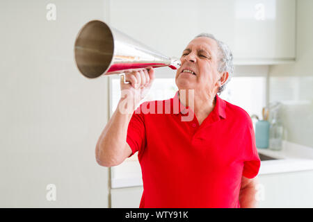 Älterer Mann shouthing durch vintage Metall Megaphon aufgeregt Stockfoto