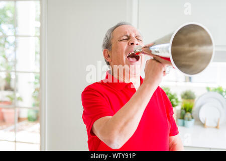 Älterer Mann shouthing durch vintage Metall Megaphon aufgeregt Stockfoto