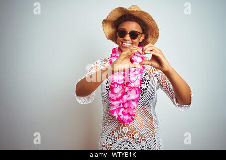 Junge afrikanische amerikanische Frau mit afro Haar Blume von Hawaii Lei über isolierte Hintergrund lächelnd in Liebe mit Herz und Form mit h Stockfoto