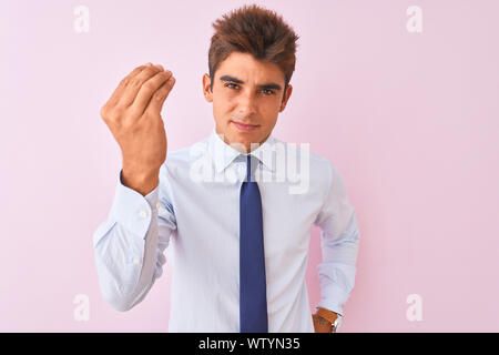 Junge gut aussehender Geschäftsmann mit Hemd und Krawatte stehend über isolierte rosa Hintergrund tun Italienische Geste mit der Hand und den Fingern zuversichtlich expressi Stockfoto