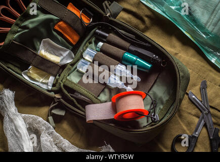 Pocket Militär outdoor Erste Hilfe Kit auf Khaki canvas Hintergrund Stockfoto