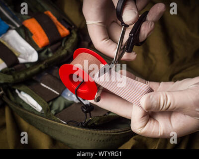 Pocket Militär outdoor Erste Hilfe Kit auf Khaki canvas Hintergrund Stockfoto