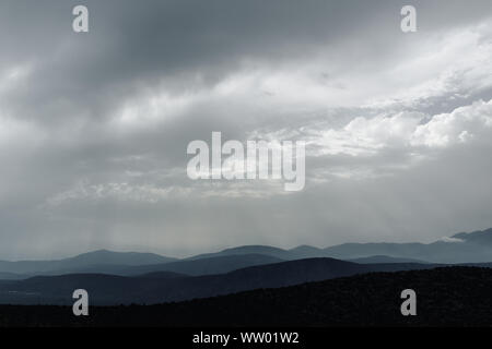 Spektakulären blue und cyan Bergketten Silhouetten. Dramatische bewölkten Himmel. Delphi, Griechenland Stockfoto