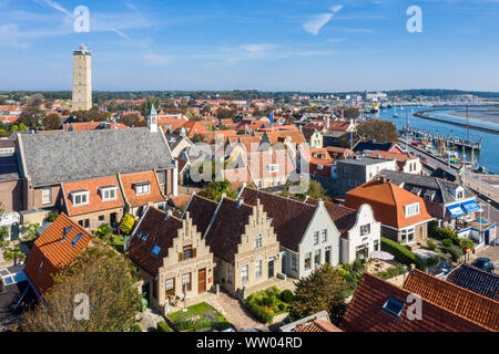 Niederlande, Terschelling - Aug 25, 2019: Leuchtturm Brandaris und Westerkerk, den Hafen und das historische Häuser von West-Terschelling Stadt. Flachwasser Stockfoto