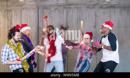 Multiethnische Gruppe junger happy and Business Leute tanzen und in Konfetti Party und Silvester feiern in der betonwand an Stockfoto