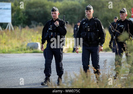 Französische Polizisten bewegen Migranten an einem Camp in Calais, Frankreich. Stockfoto