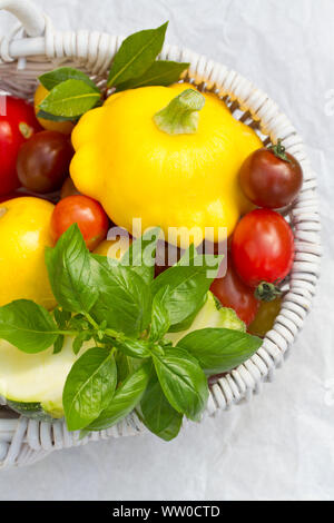 Korb der Kürbisse und Tomaten mit frischen Kräutern Stockfoto