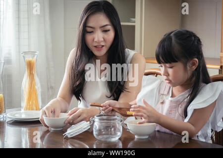 Glücklicher Moment zusammen! Asiatische Mutter und Tochter bereiten ihr essen gemeinsam in der Küche. Stockfoto