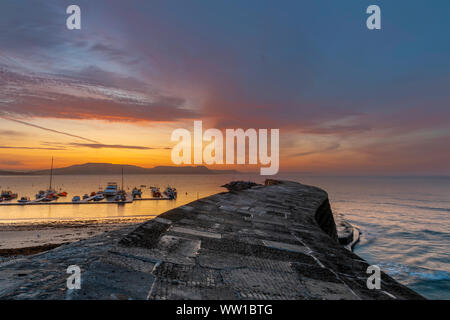 Lyme Regis, Dorset England Sonnenaufgang am Cobb, das 14. Jahrhundert Hafenmauer von Lyme Regis Stockfoto