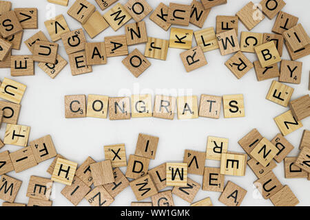 Herzlichen Glückwunsch Nachricht Dinkel in Scrabble Briefe von verschiedenen Fliesen umgeben Stockfoto