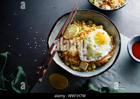 Vegetarisch gebratener Reis mit Tofu, Erbsen und Gemüse. Asiatische Küche, gesundes Mittagessen Stockfoto
