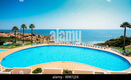 Leeren Pool mit Blick auf den Strand und das Meer in der Algarve, Portugal, im Sommer - Paradise Holiday theme Stockfoto