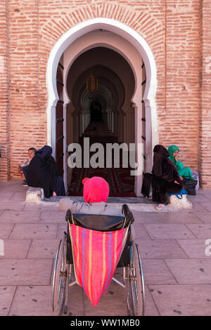 Marrakesch, Marokko - März 13, 2018: ein Mann im Rollstuhl wartet am Eingang der Koutoubia Moschee für jemanden, der ihm zu helfen Stockfoto