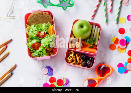 Lunch Box mit Salat und gesundes Essen für die Schule. Ansicht von oben Bild mit Buntstifte und Gläser für Kinder Stockfoto