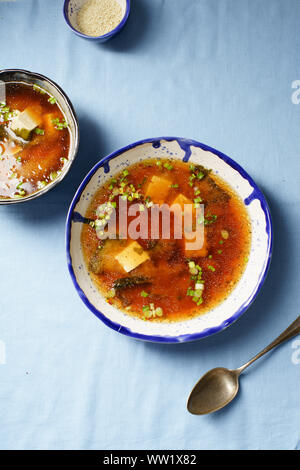 Japanische Miso Suppe mit Tofu, Wakame Algen, Frühlingszwiebeln und Paprika Flocken Stockfoto