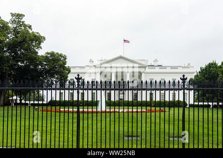 Die Ostseite des Weißen Haus mit Brunnen, Eisen Zaun und roten Blüten im Vordergrund. Stockfoto