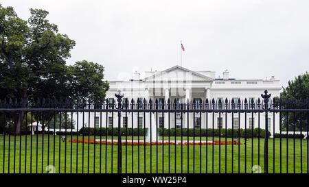 Die Ostseite des Weißen Haus mit Brunnen, Eisen Zaun und roten Blüten im Vordergrund. Stockfoto