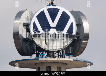 Hannover, Deutschland. 12 Sep, 2019. Arbeitnehmer Abrollen der neue Volkswagen Logo auf dem vwn Turm von Volkswagen Nutzfahrzeuge. Auf der im Volksmund als "Telemoritz" die drei riesigen VW-Logos sind derzeit ausgetauscht werden. Volkswagen hat sein Logo mehr einfach entworfen und ist nun Austausch weltweit. Credit: Julian Stratenschulte/dpa/Alamy leben Nachrichten Stockfoto