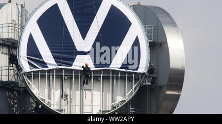 Hannover, Deutschland. 12 Sep, 2019. Arbeitnehmer Abrollen der neue Volkswagen Logo auf dem vwn Turm von Volkswagen Nutzfahrzeuge. Auf der im Volksmund als "Telemoritz" die drei riesigen VW-Logos sind derzeit ausgetauscht werden. Volkswagen hat sein Logo mehr einfach entworfen und ist nun Austausch weltweit. Credit: Julian Stratenschulte/dpa/Alamy leben Nachrichten Stockfoto