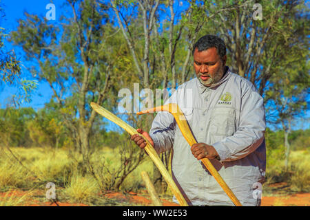 Der Kings Creek Station, Northern Territory, Australien - 21.August 2019: Australische Aborigines Mann hält eine eingeborene Waffe der Boomerang von luritja verwendet Stockfoto