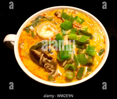 Leckere asiatische Fisch Curry Laksa Suppe mit Garnelen, Gemüse, Nudeln, Tofu Sojasprossen in einer würzigen cremiger Kokosnuss Brühe Stockfoto