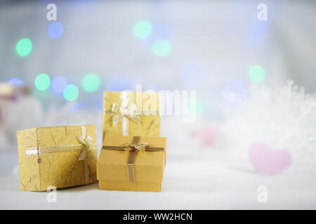 Gelbe Geschenkboxen auf dem weißen Pelz, Bokeh-Hintergrund, mit Kopierraum für die Begrüßung der Saison, frohe weihnachten oder Happy New Year. AF-Punktauswahl, unscharfe Anzeige Stockfoto