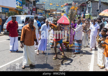 Pusellawa, Sri Lanka, 12. März 2019: Hindu Festival der Thaipusam - Body Piercing Rituale unter dem Blut Mond. Anhänger ziehen Warenkorb durch Haken in der Haut. Stockfoto