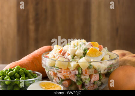 Die traditionellen russischen Salat und Zutaten für Weihnachten. Olivier Salat auf hölzernen Tisch Stockfoto