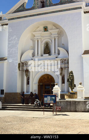 COPACABANA, BOLIVIEN - Oktober 18, 2014: Nicht identifizierte Personen sitzen und stehen vor dem Eingang der Basilika Unserer Lieben Frau von Copacabana Stockfoto