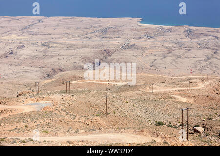 Einsame Schotterstraße durch eine karge Landschaft von Felsen in den Bergen in Jebel Akhdar, Oman führenden Stockfoto