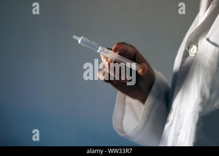 Medizin Konzept: Junge weibliche Arzt mit einer Spritze in der Hand. Impfung Zeit. Stockfoto