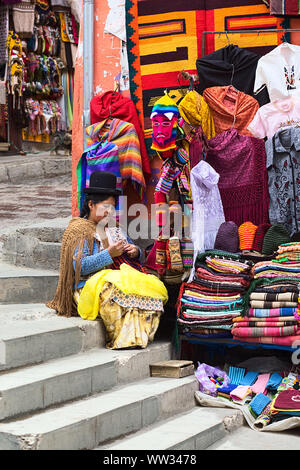 LA PAZ, Bolivien - November 10, 2014: Nicht identifizierte Frau tun Häkeln sitzen auf der Treppe neben ihr kleine Straße stand an der Ecke Stockfoto