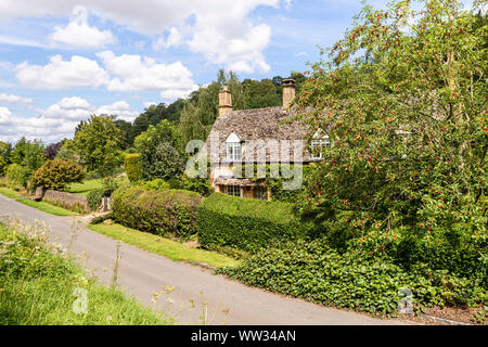 Ein Häuschen neben dem Lane im Cotswold Dorf Buckland, Gloucestershire, Großbritannien