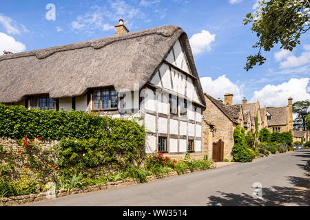 Altes Fachwerkhaus Gebäude und Häuser aus Stein neben der Fahrbahn in der Cotswold Dorf Stanton, Gloucestershire, Großbritannien Stockfoto