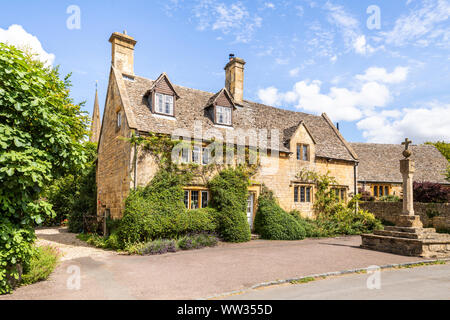 Die alten steinernen Kreuz und sonnenuhr vor der Hütte im Cotswold Dorf Stanton, Gloucestershire, Großbritannien Stockfoto