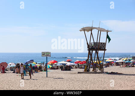 IQUIQUE, CHILE - Januar 23, 2015: Rettungsschwimmer Wachtturm, Sonnenschirme und viele Besucher am Strand Cavancha am 23. Januar 2015 in Iquique, Chile. Stockfoto