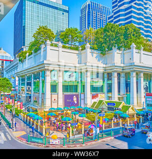 BANGKOK, THAILAND - 24 April 2019: Der kleine goldene Erawan-schrein ist beliebte Wahrzeichen von Neustadt, durch die belebten Straßen umgeben, Hochhäuser, Business c Stockfoto