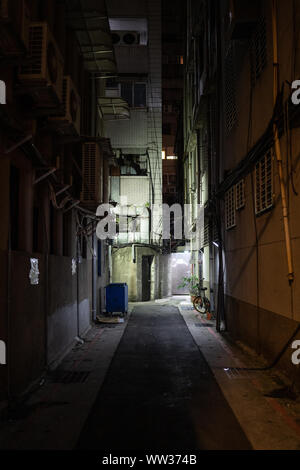 Taipei, Taiwan: Kleine dunkle Gasse in Taipeh in der Nacht. Sehr kleine Seitenstraße mit Licht am Ende. Stockfoto