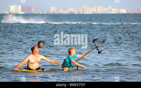 Murcia, Spanien, 23. August 2019: Sportlerinnen und Sportler üben Kitesurfen an der spanischen Küste. Kite Surfen Lektionen für die Einleitung an der Küste Stockfoto