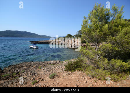 Ein Motorboot in der Nähe von Cala Bramassa, einer kleinen Bucht an der sardischen Meer verankert, in der Porto Conte Natural Park, an einem sonnigen Sommertag Stockfoto