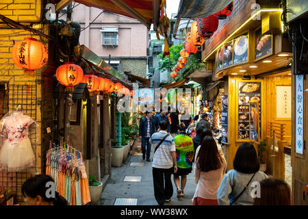 Jiufen Old Street mit Touristen wandern und Shopping. Traditionelle Chinesische Laternen entlang der schmalen Straße hängen. Stockfoto