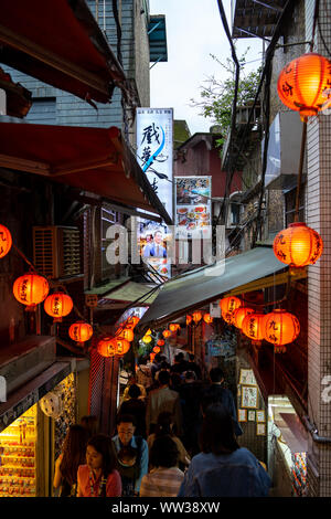 Schmale Jiufen Old Street mit Touristen wandern und Shopping. Traditionelle Chinesische Laternen entlang der schmalen Straße hängen. Stockfoto