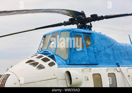 Kleine weiße Hubschrauber mit einem blauen Streifen auf dem grünen Rasen. Stockfoto