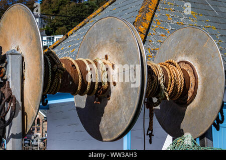 Trawler Fischernetz Windentrommeln auf Entladen Bucht im hübschen Fischerdorf Looe, Cornwall, Großbritannien Stockfoto