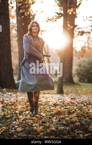 Hübsches Mädchen Wandern im Herbst Park. Schönen Herbst sonniges Wetter. Junge Frau genießen. Frauen Mode. Herbstferien. Menschen, Herbst und Leben Stockfoto