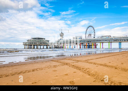 Scheveningen, Niederlande. Strand mit Reifenspuren, Pier, Riesenrad und die Nordsee. Stockfoto