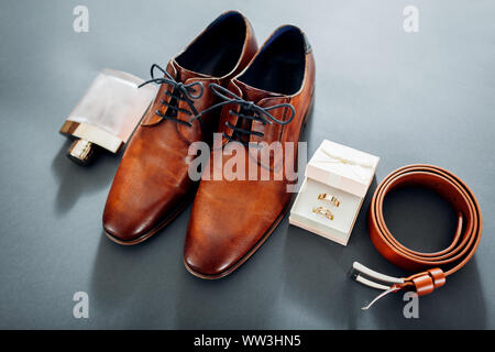 Für den Bräutigam Hochzeit Zubehör. Aus braunem Leder, Schuhe, Gürtel, Parfum, goldene Ringe. Männliche Mode Stockfoto